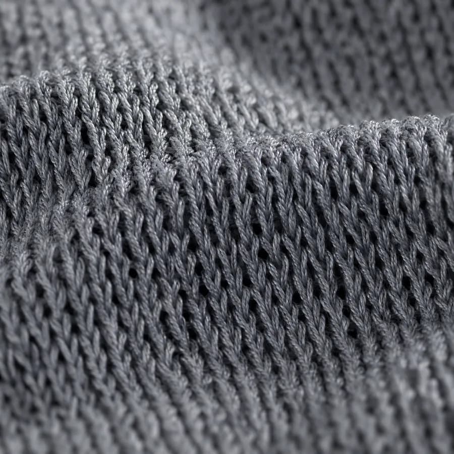 Macro view of technical single jersey showing its continuous-filament polyester, fine loop structure, low absorbency