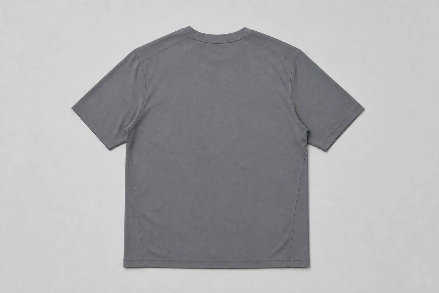 Technical tee laid flat on a plain studio background, photographed from above