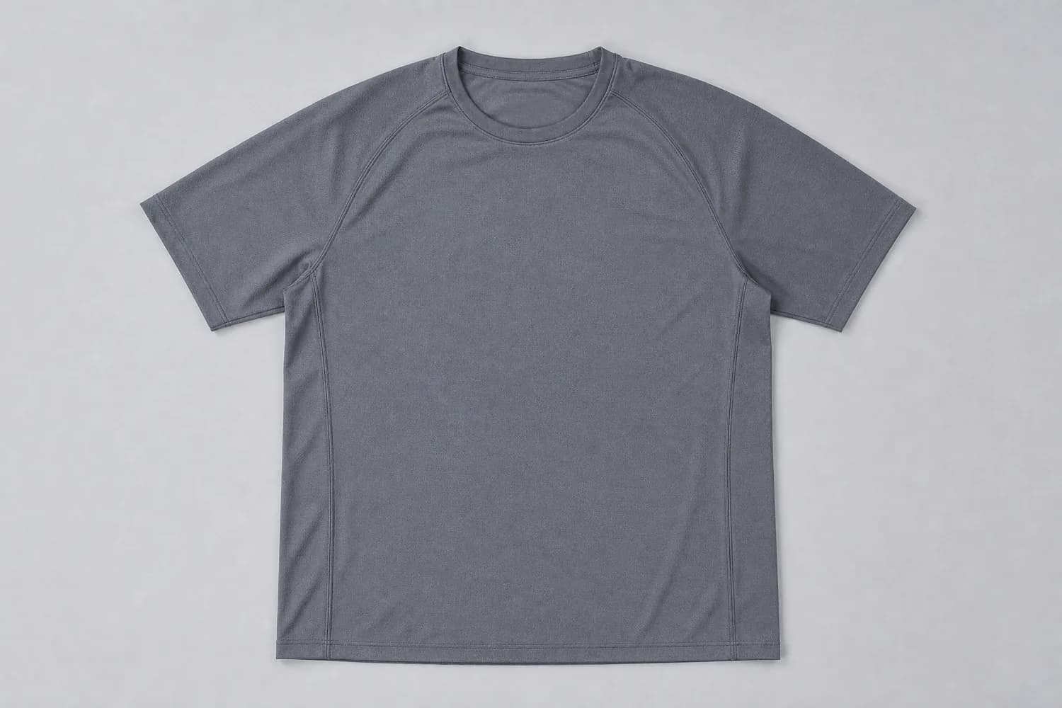 Technical tee laid flat on a plain studio background, photographed from above